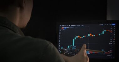 Man watches altcoins pump on crypto exchange laptop.