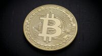 Photo illustration of Bitcoin coin on black background for news article about crypto markets crashing